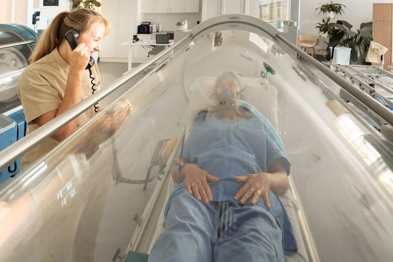 Client inside a TGA-registered hard-shell hyperbaric chamber at Inspiring Choices Gold Coast